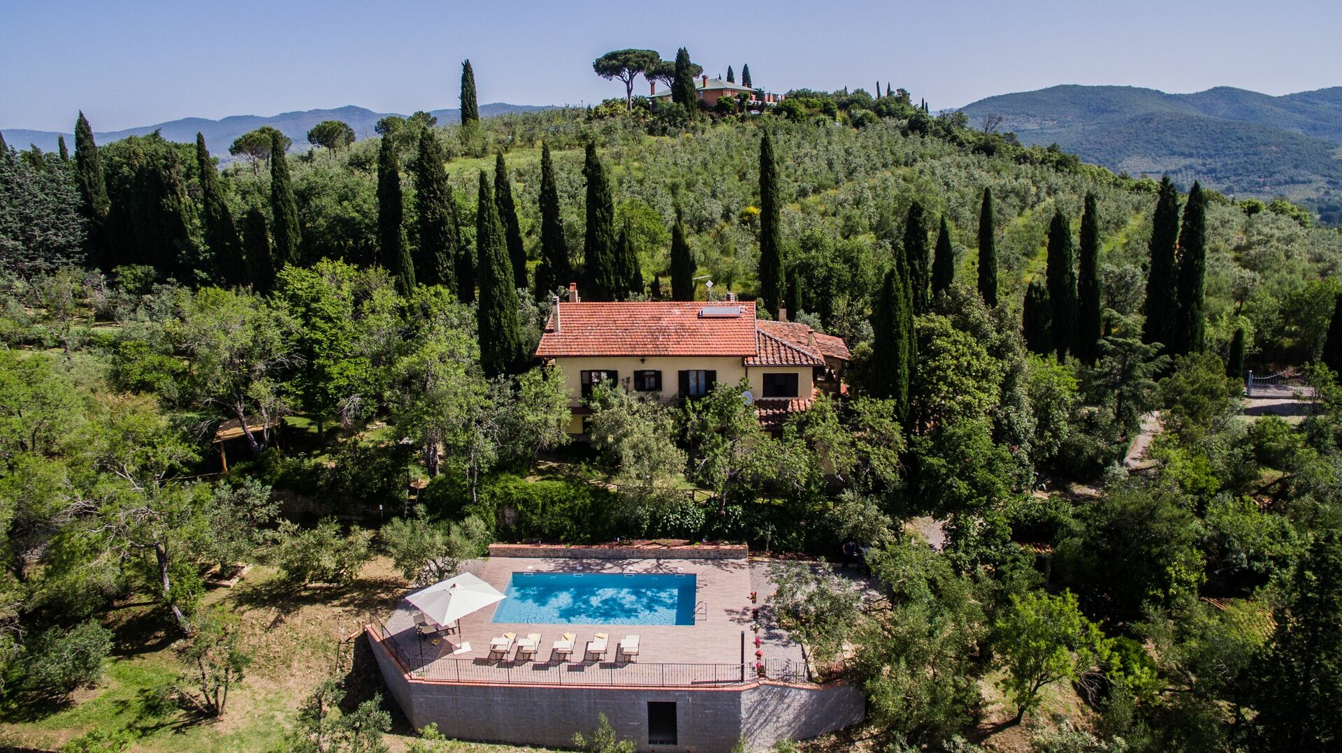 Ferienhaus in der Toskana mit Pool, Terrasse, Sonnenschirm und Liegestühlen mit Blick auf die Weinberge